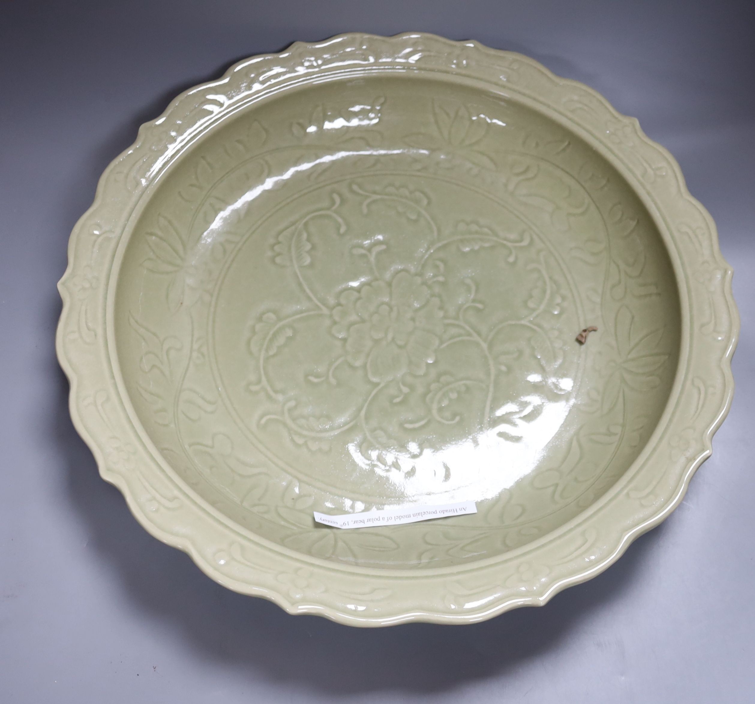 A large Chinese celadon glazed dish, a Chinese green crackle glaze ewer and cover and a 'frog pond' bowl (3)